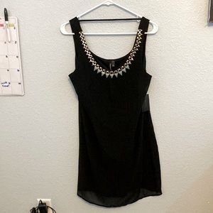 A medium black heartsoul dress with jewelry around the neck.